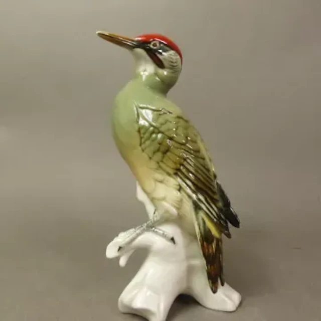 A Karl Ens porcelain figure of a green woodpecker, marked 7527, height 25cm.
