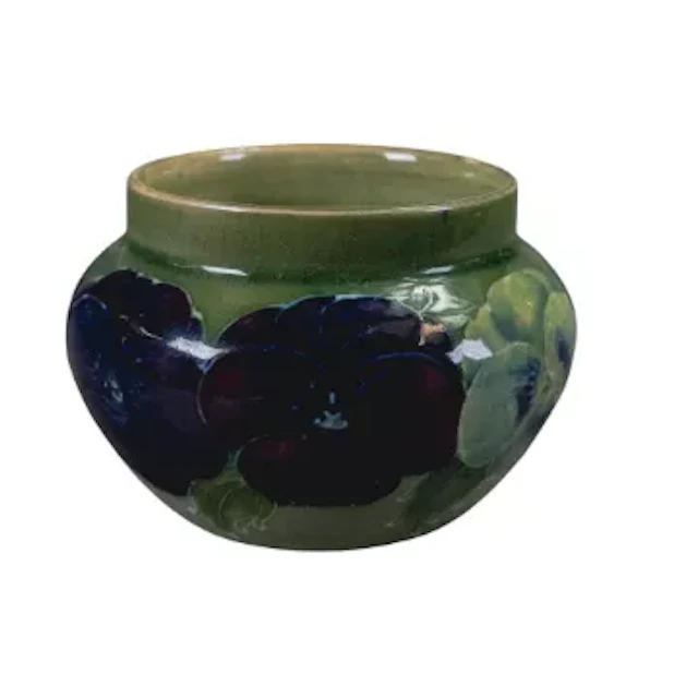 William Moorcroft early pansy vase on pale green ground, h.6cm. (AF)