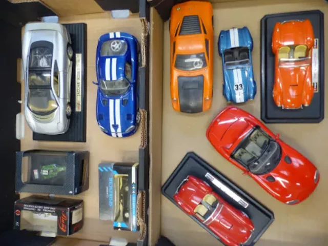 A collection of die cast vehicles, some boxed, some on display stands