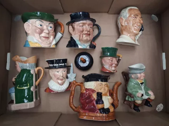 A collection of character jugs, Toby jugs and a character teapot