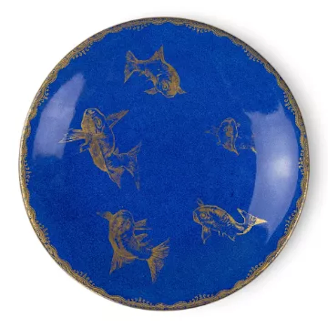 An early 20th Century Wedgwood plate with gilded fish against a powder
