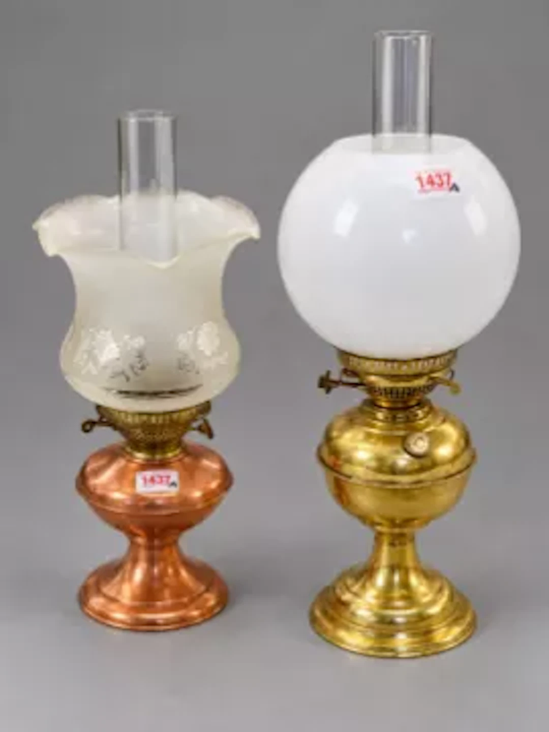 Two oil lamps, one having a brass body with clear glass chimney and