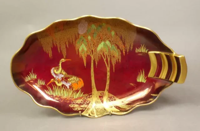 A Carlton Ware shaped dish enamelled with cranes onto a Rouge Royale