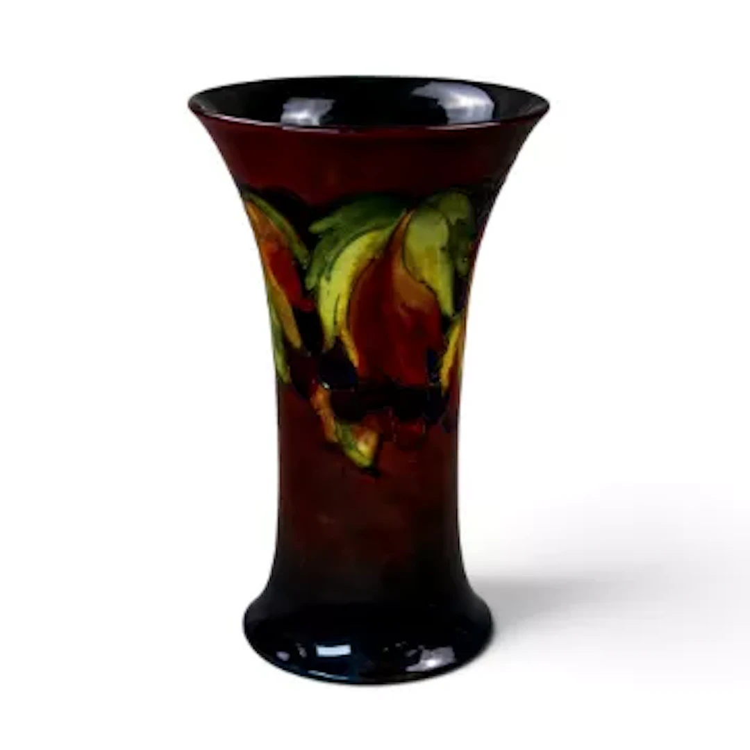 A Moorcroft Leaf & Berry pattern vase under a rich flambe glaze by
