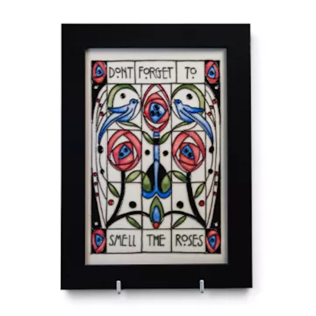A Moorcroft plaque with the motto 'Don't forget to smell the Roses'