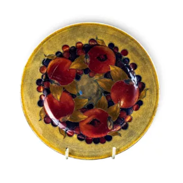 A Moorcroft tea plate in the Pomegranate design on an ochre ground