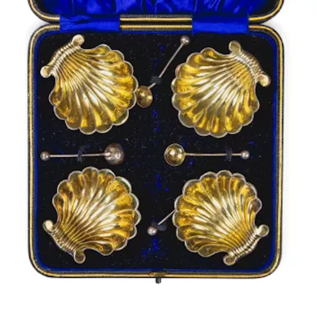 A set of 4 silver shell shaped open salts, with salt spoons, each