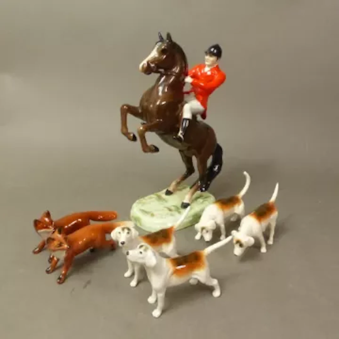 A Beswick huntsman on a rearing horse model 868, together with 4 hounds