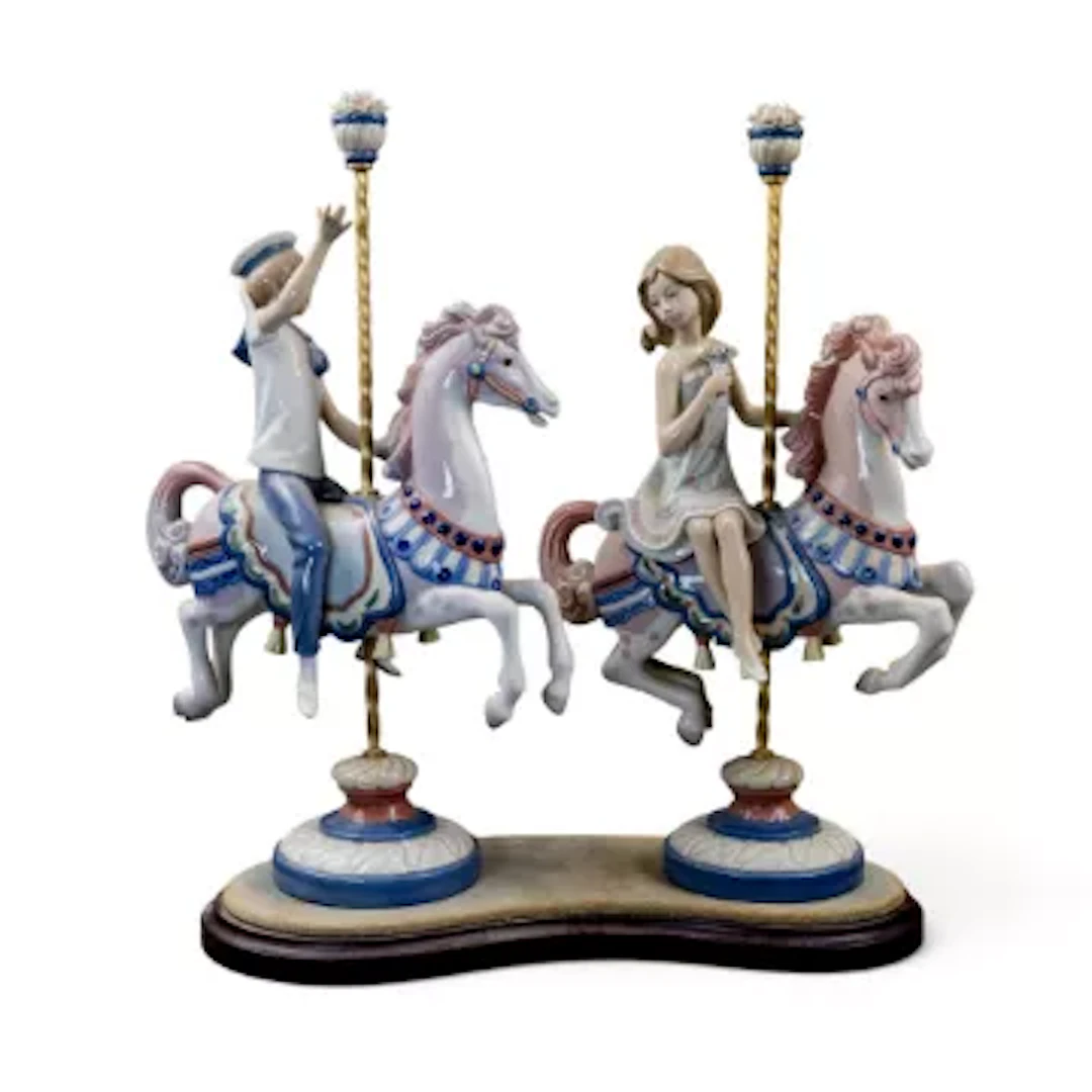 A pair of Lladro figures of a boy and girl on Carousel horses, model