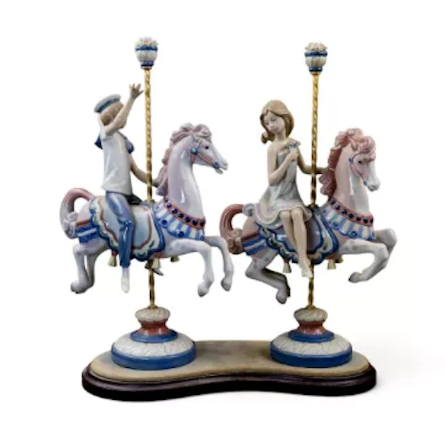 A pair of Lladro figures of a boy and girl on Carousel horses, model