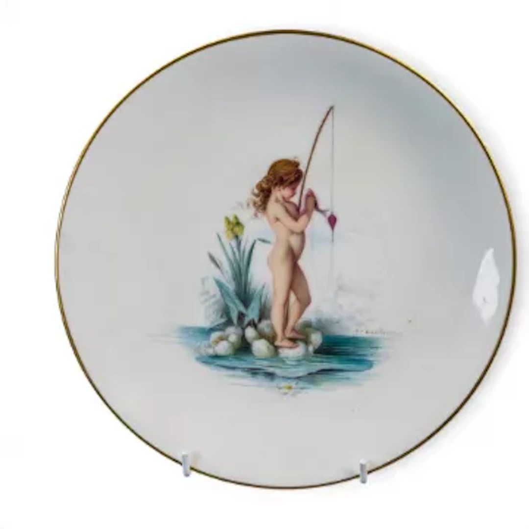 A Minton plate featuring a fishing Cherub in a water scene, signed