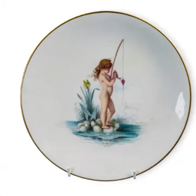 A Minton plate featuring a fishing Cherub in a water scene, signed