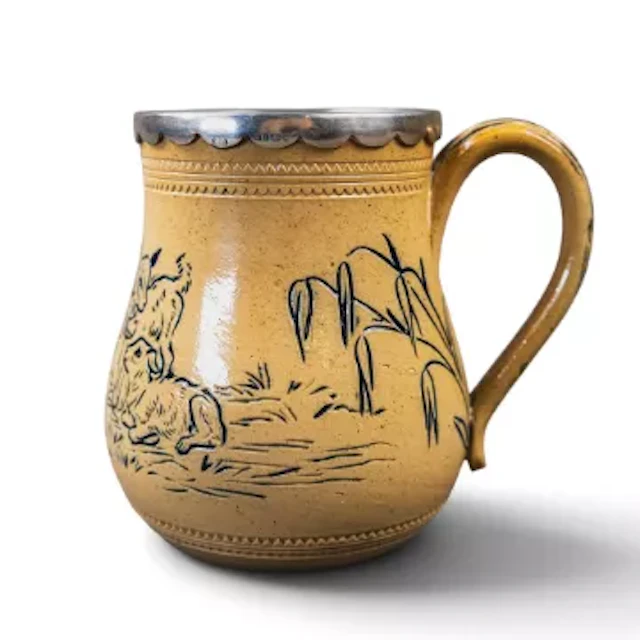 A Doulton Lambeth stoneware tankard with hallmarked silver shaped
