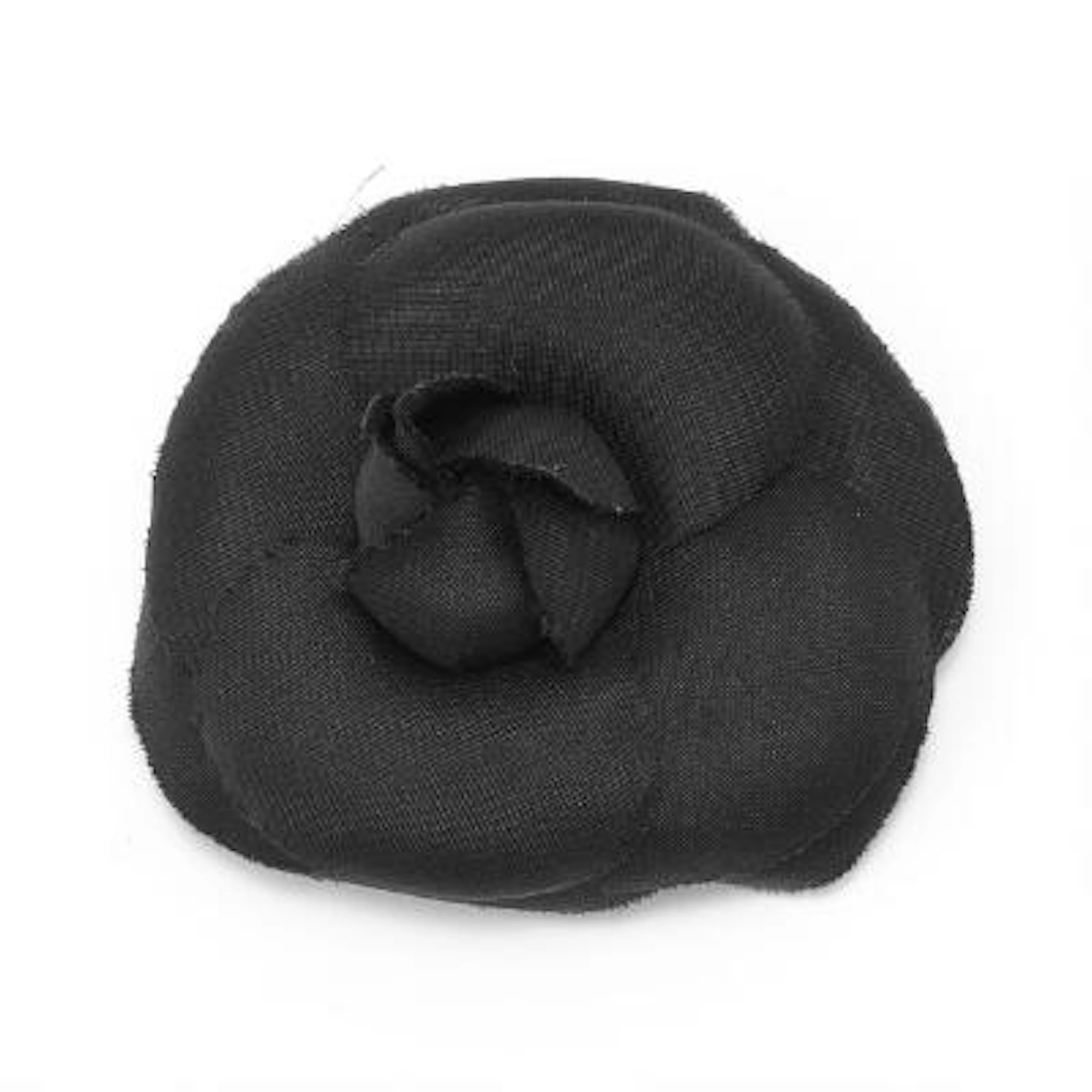 Chanel: A brooch in the shape of a carnelia flower of black fabric.