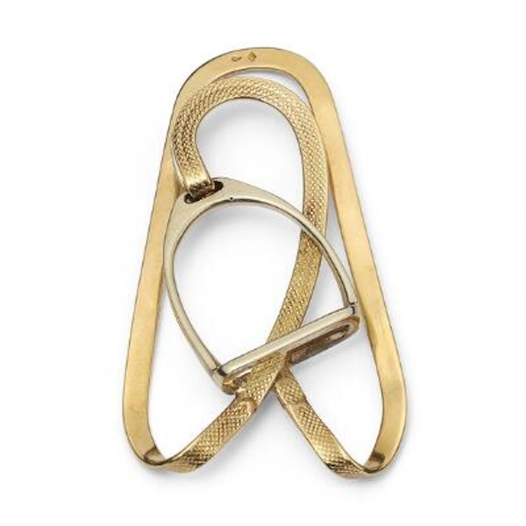 Hermès: A money clip of 18k gold in the shape of a stirrup. Marked