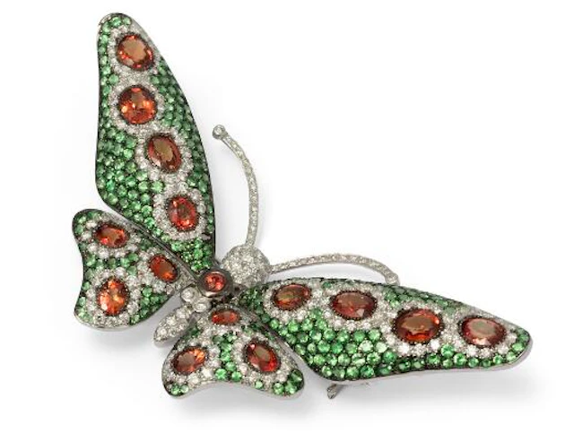 A sapphire, tsavorite and diamond butterfly brooch of 18k white gold.
