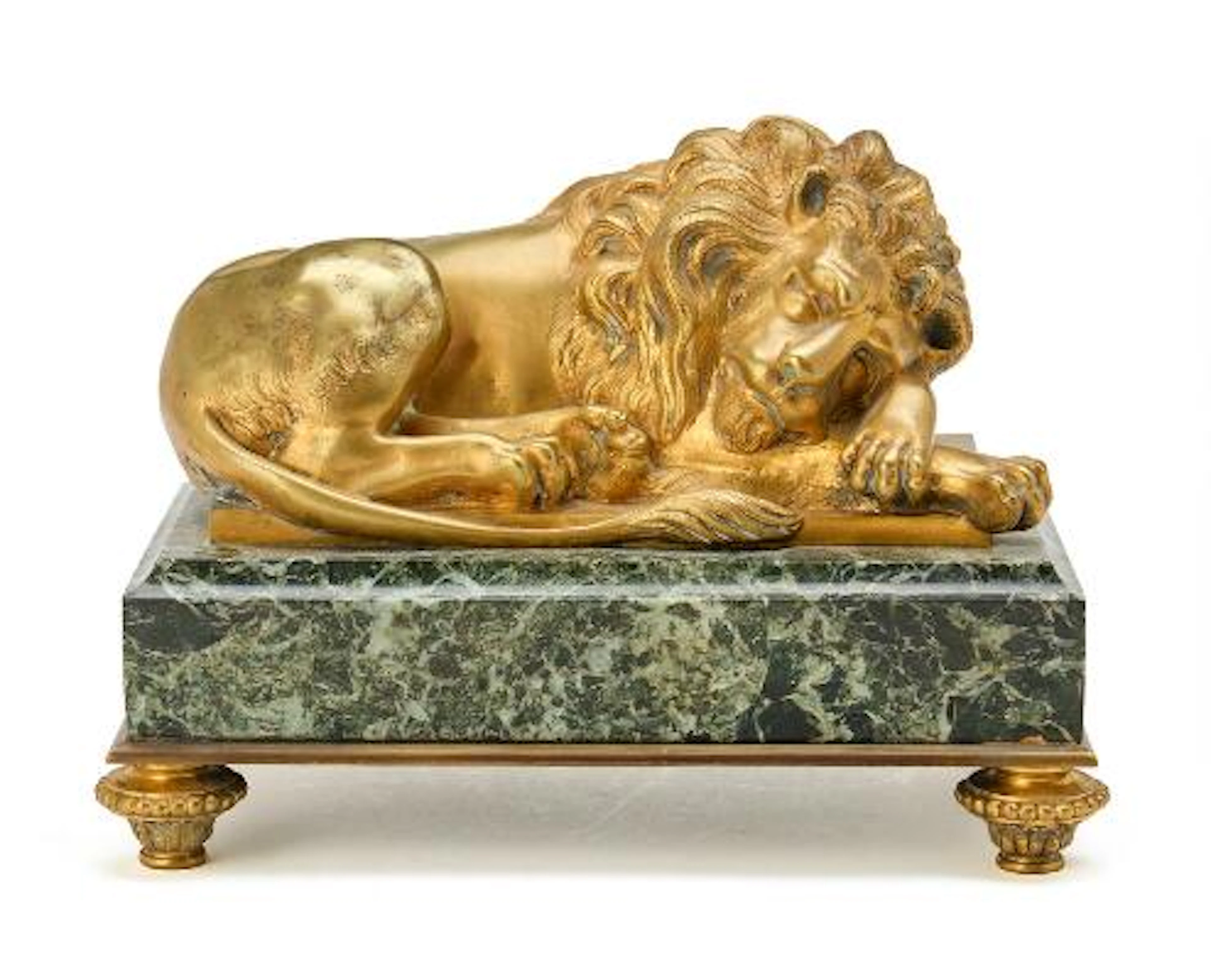 Reclining lion, figure of gilt bronze on marble plinth. H. 17 cm L.