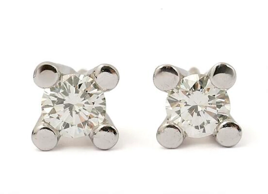 A pair of diamond ear studs each set with a diamond weighing in totap