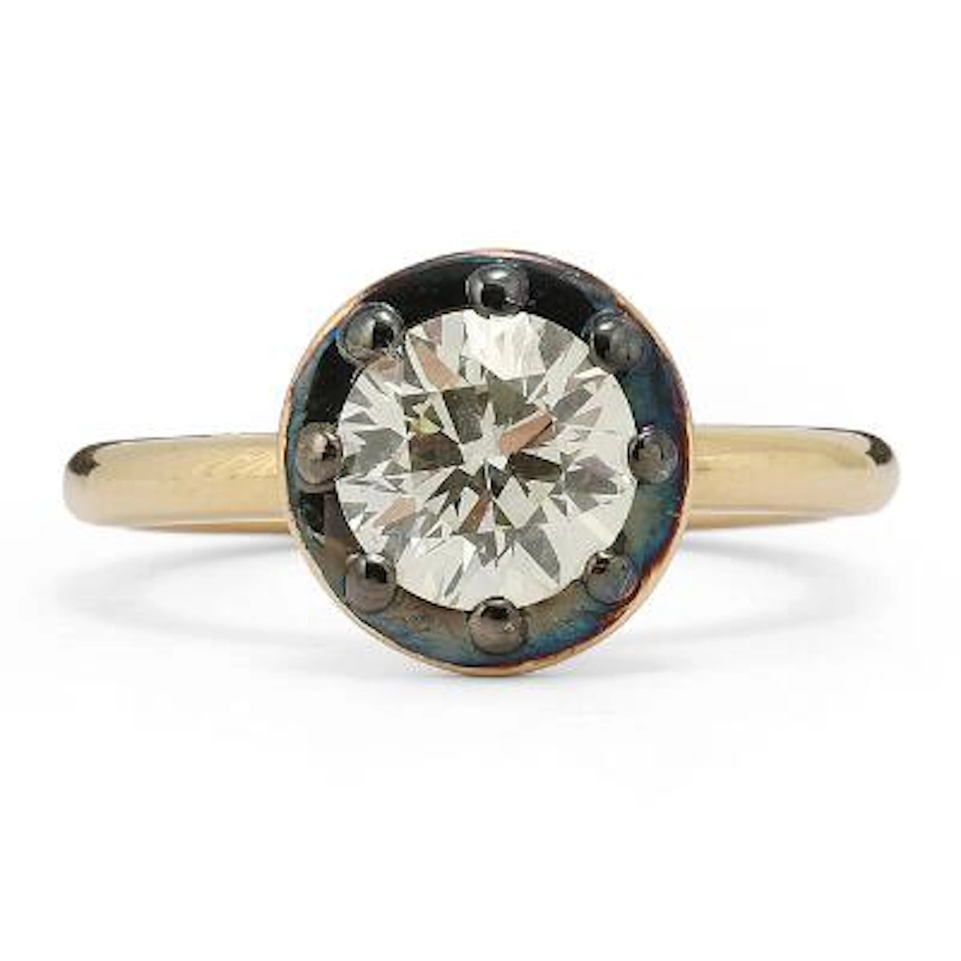 A diamond ring set with a diamond mounted in 17k gold and black rhodium-plated