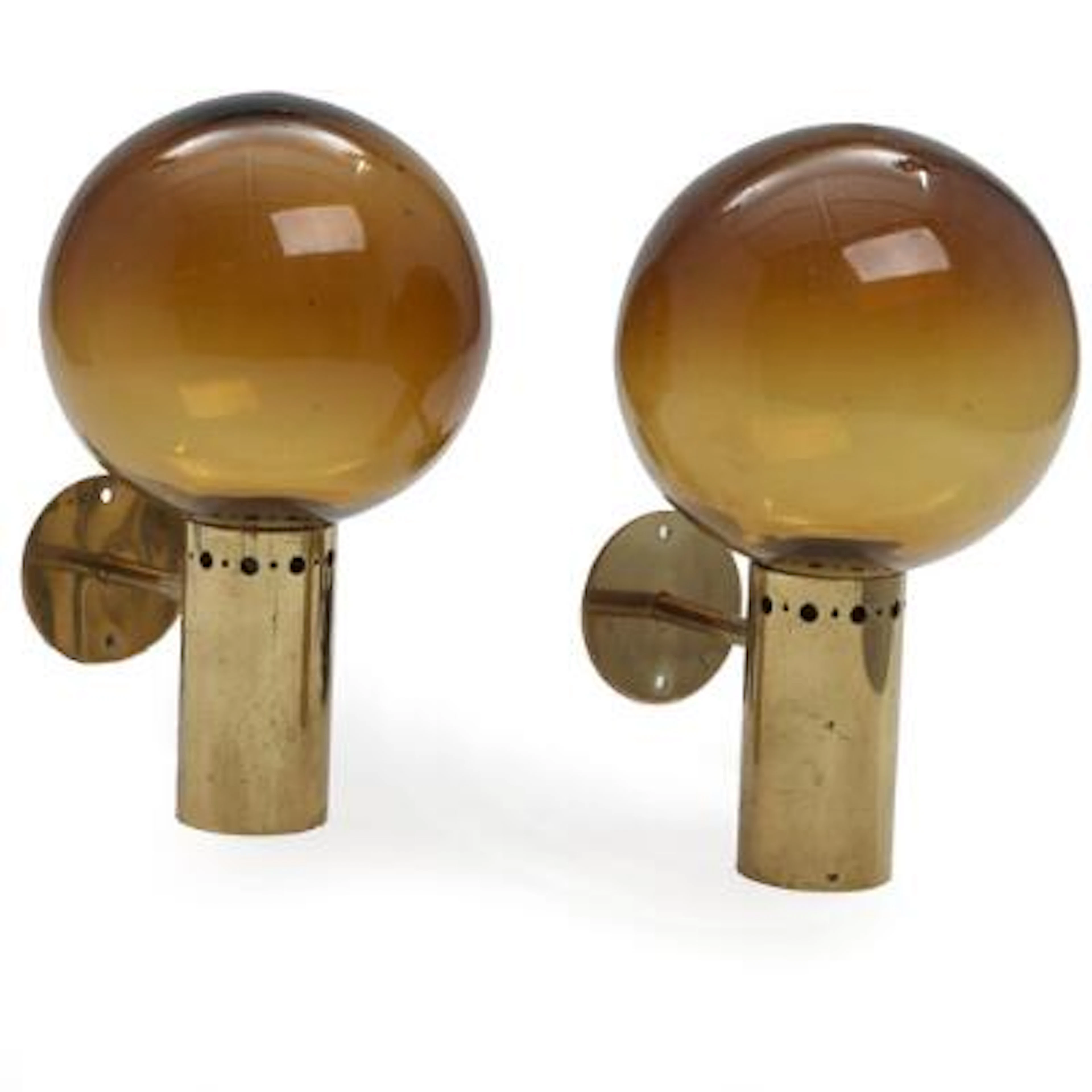 Scandinavian design: A pair of brass wall lamps with amber glass shades.