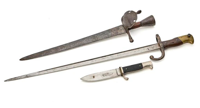 A left-hand dagger, a French bayonet, and a Scout knife. – Bruun Rasmussen