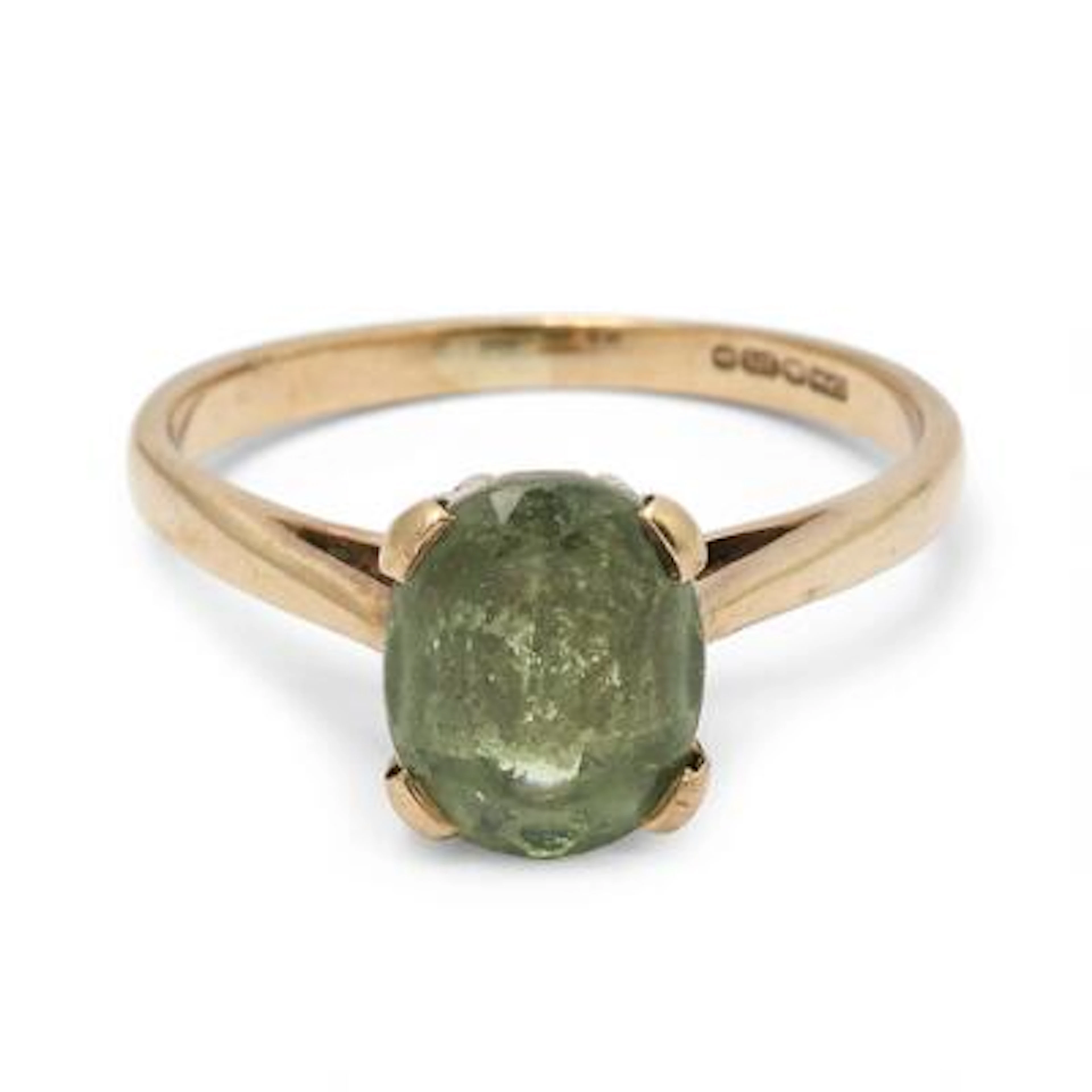 A moldavite ring set with circular-cut moldavite, mounted in 14k gold.