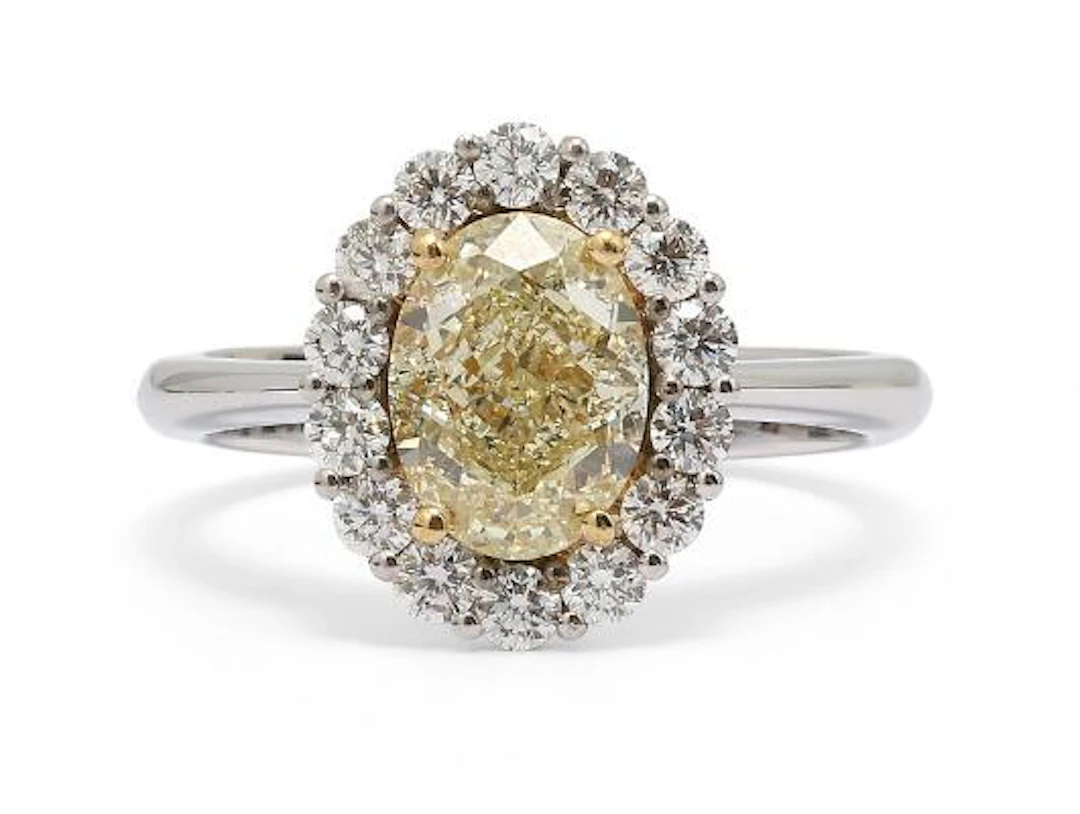 A diamond ring set with an oval-cut yellow diamond encircled by diamonds