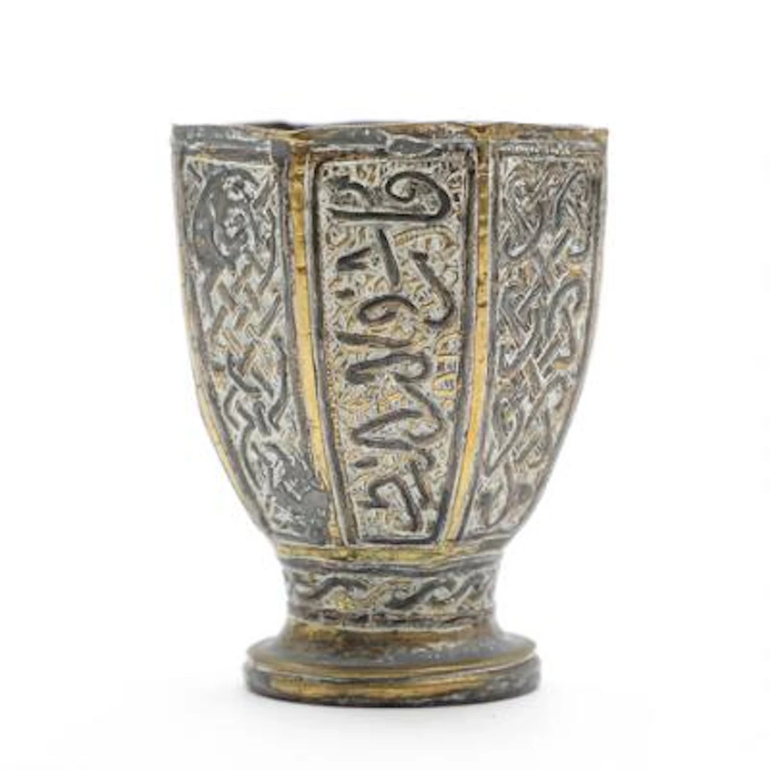 Islamic octagonal beaker in partially gilt brass, richly decorated