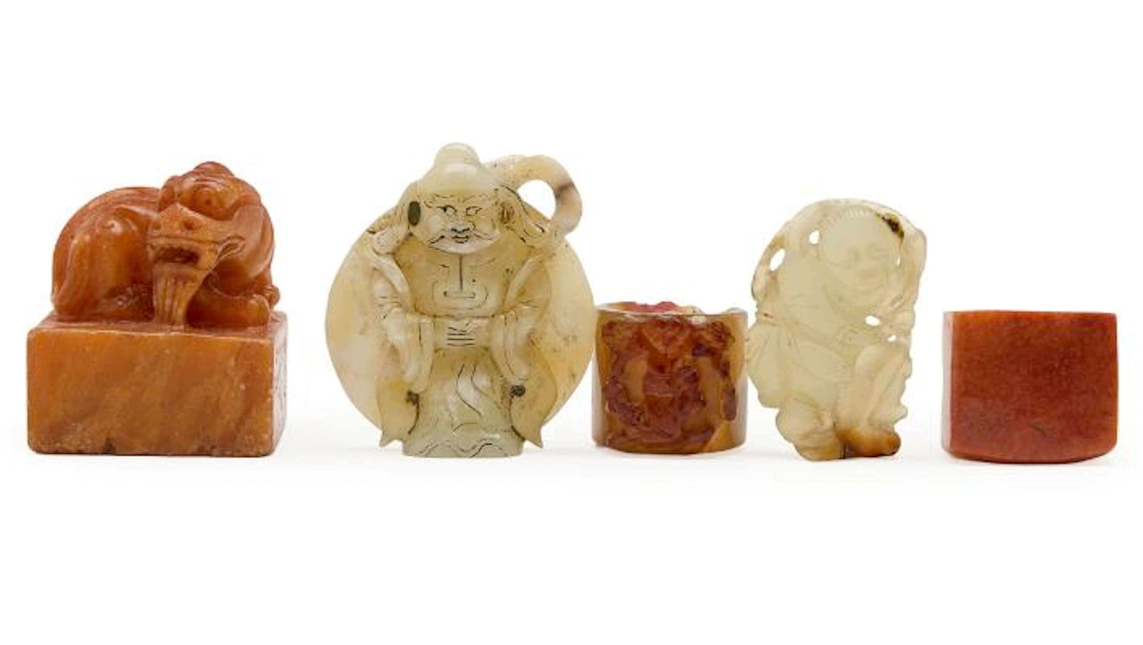 Two Chinese thumb rings and a seal stone of carved soapstone, further