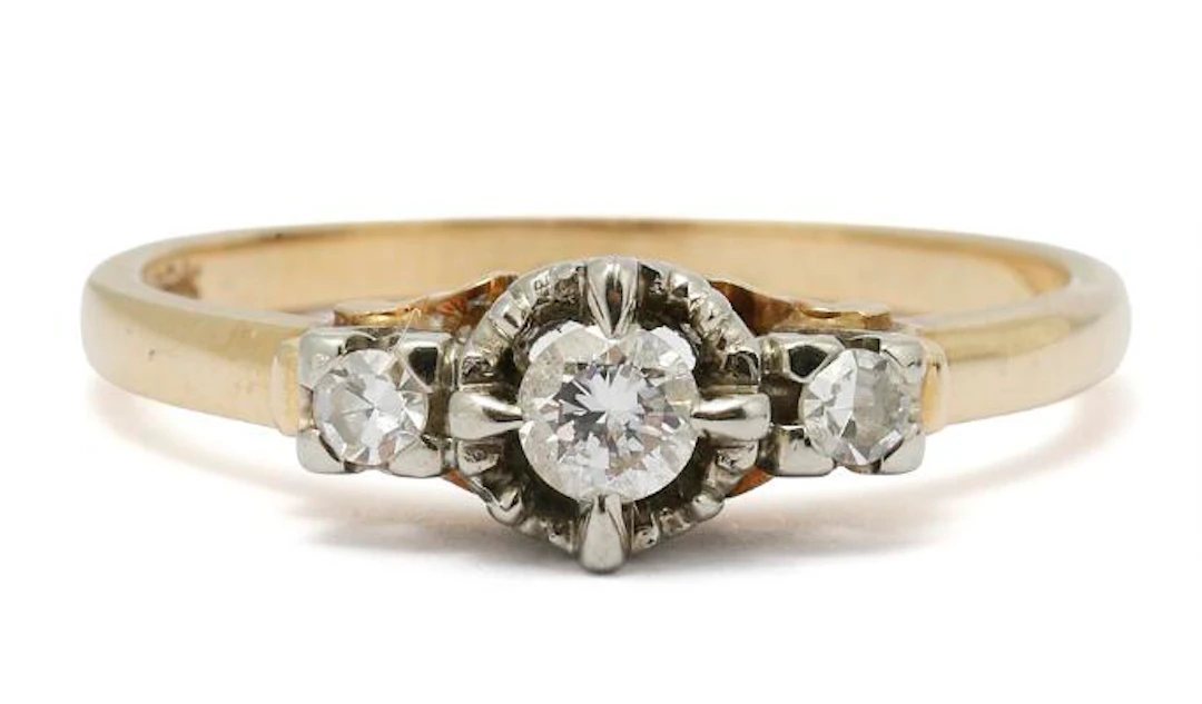 A diamond ring set with three diamonds, mounted in 18k gold and white