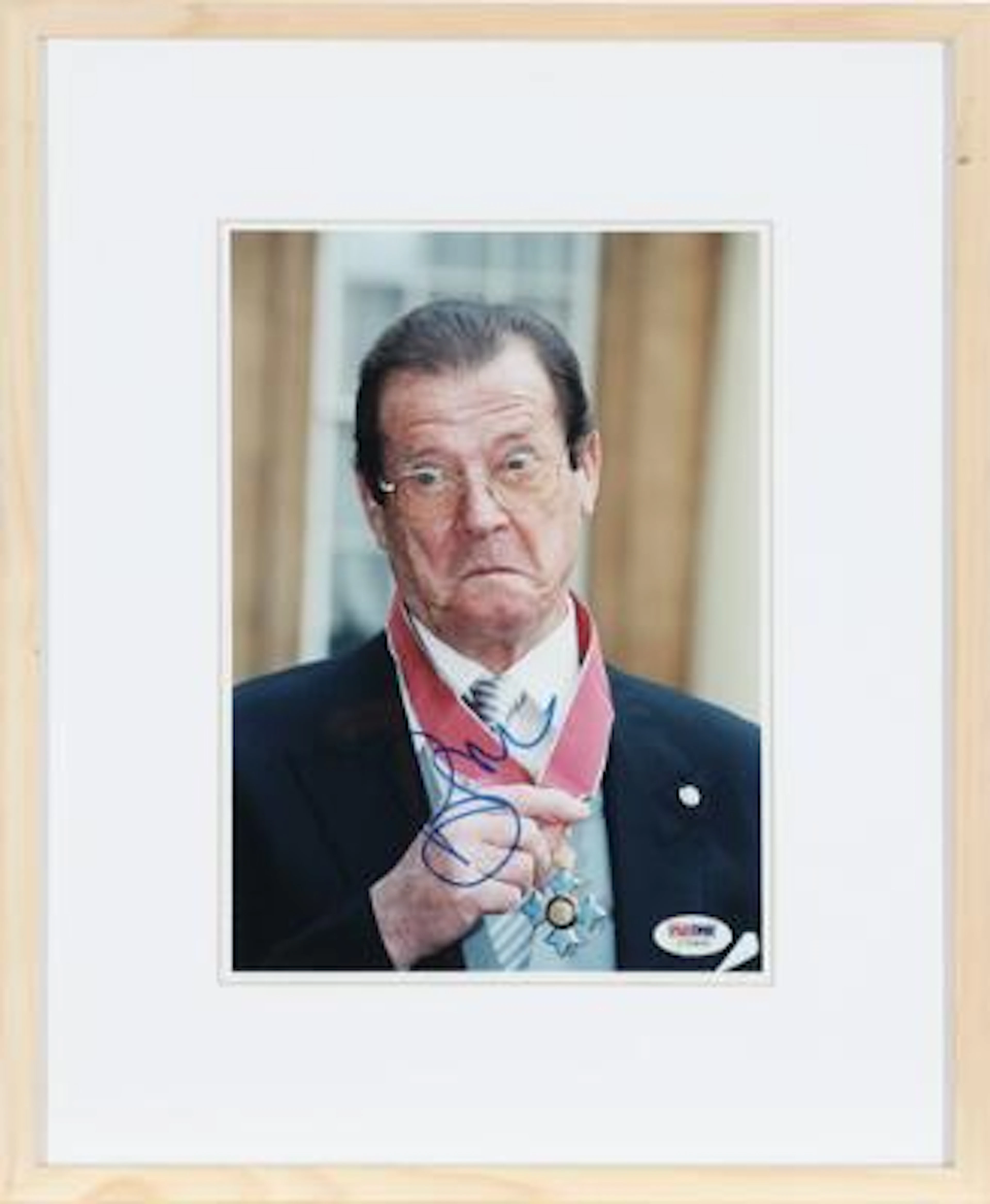 Signed colour press photograph of English actor Sir Roger Moore (1927–2017).