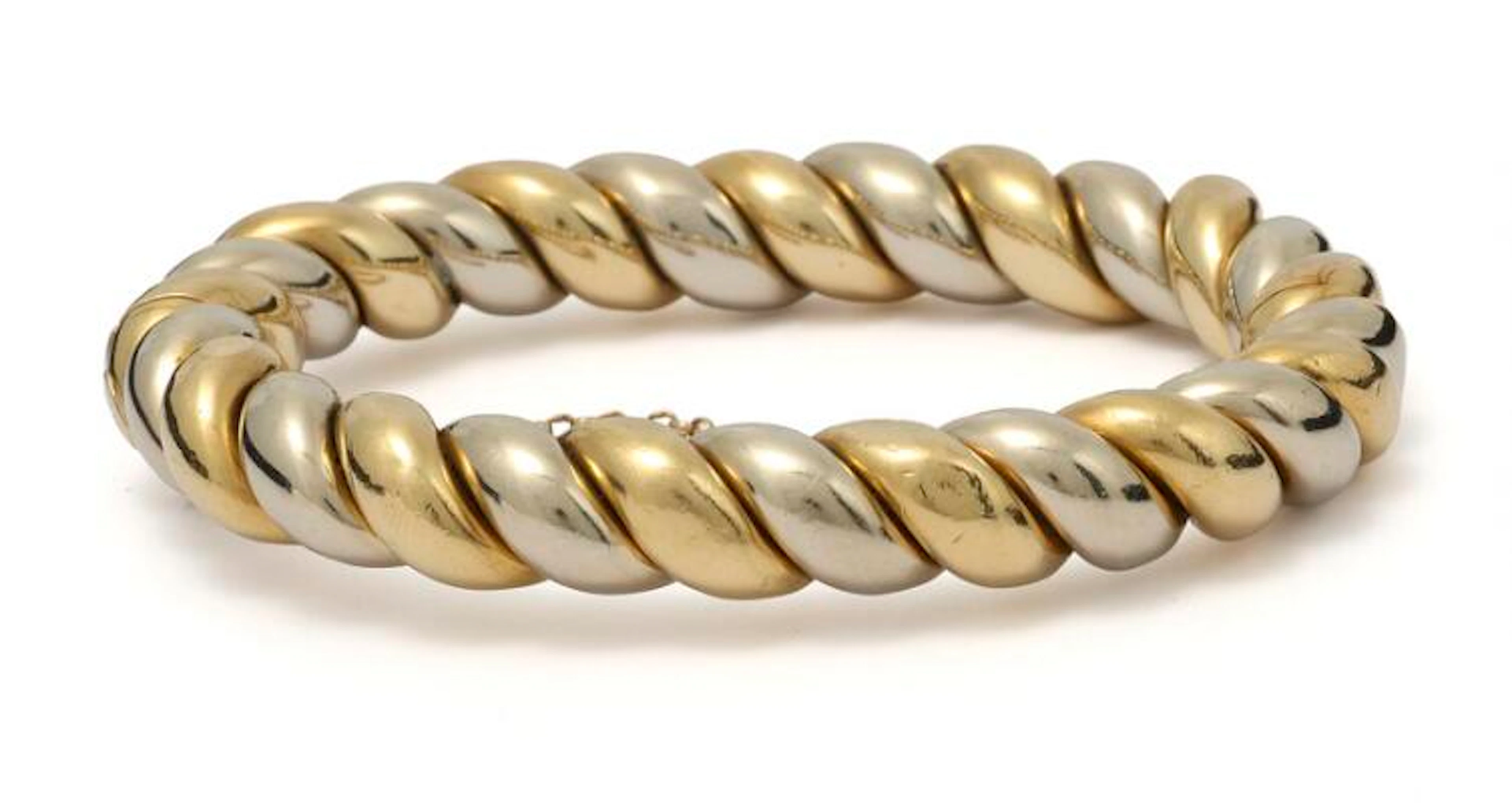 A bangle of 18 two-toned gold. Weight app. 66 g. W. 10 mm. Diam. 4.8