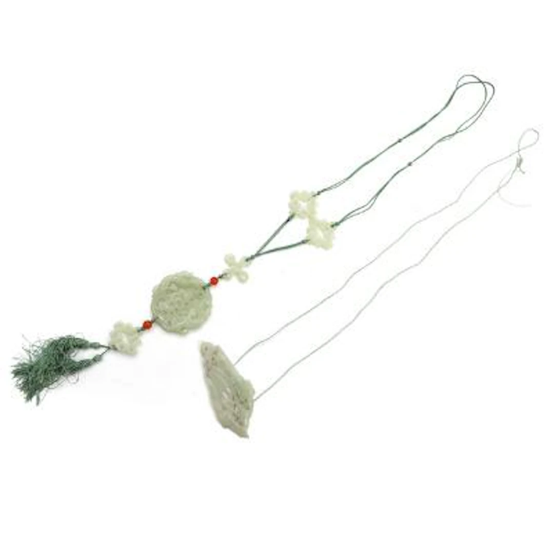 Two Chinese jade pendants, the one with a double phoenix. 20th century.