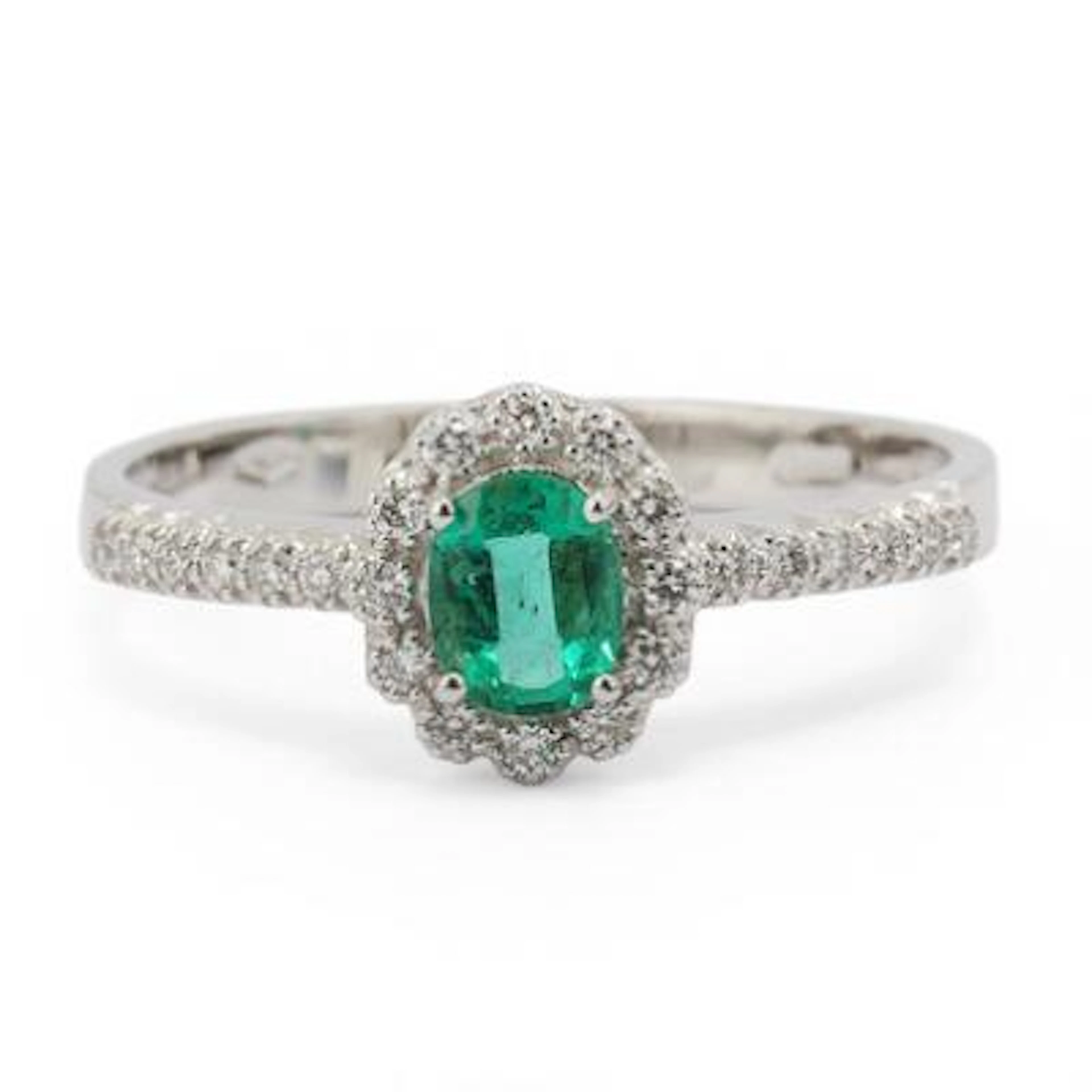 An emerald ring set with an emerald and numerous diamonds mounted