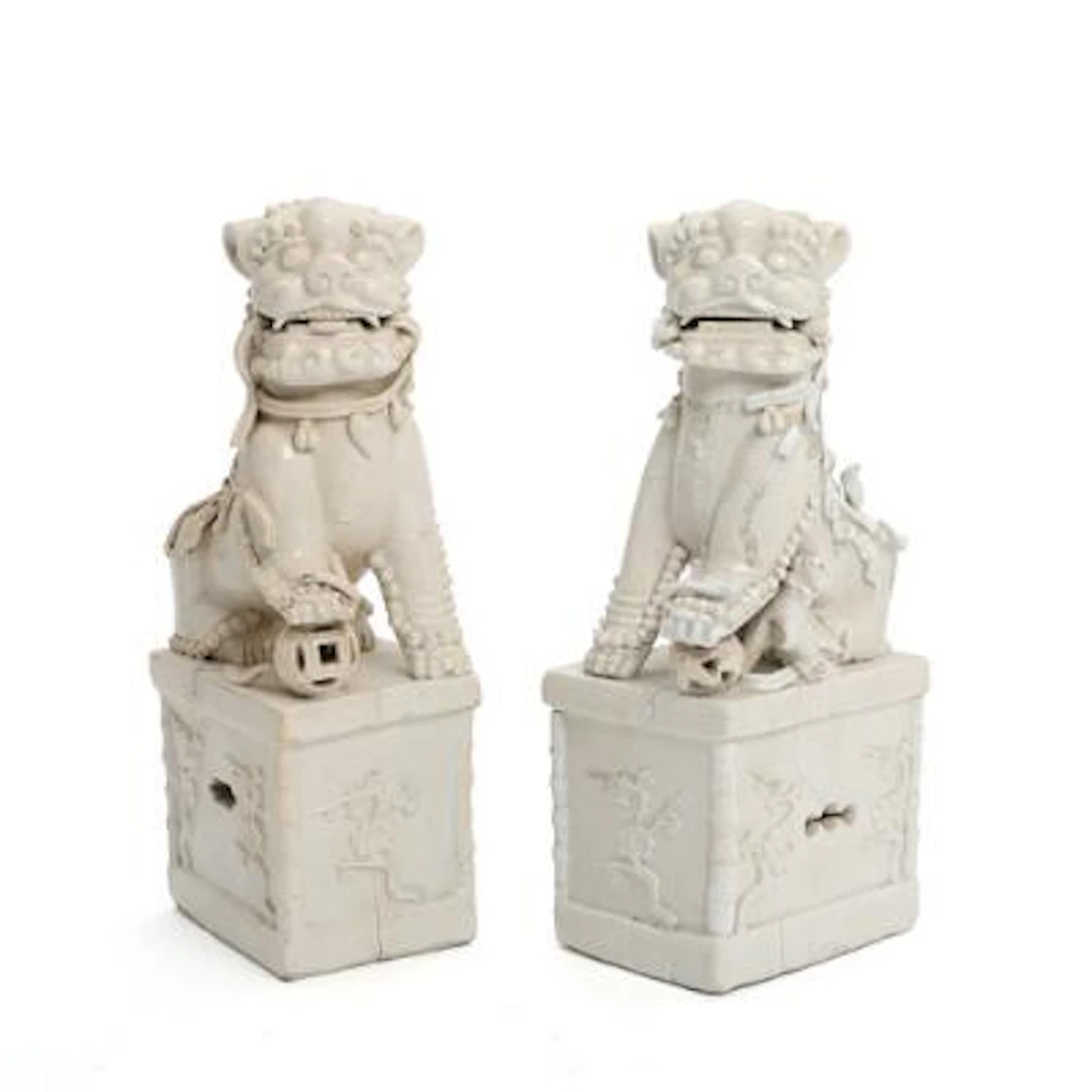 A pair of Chinese foo dogs in porcelain, seated on pedestals. Qing