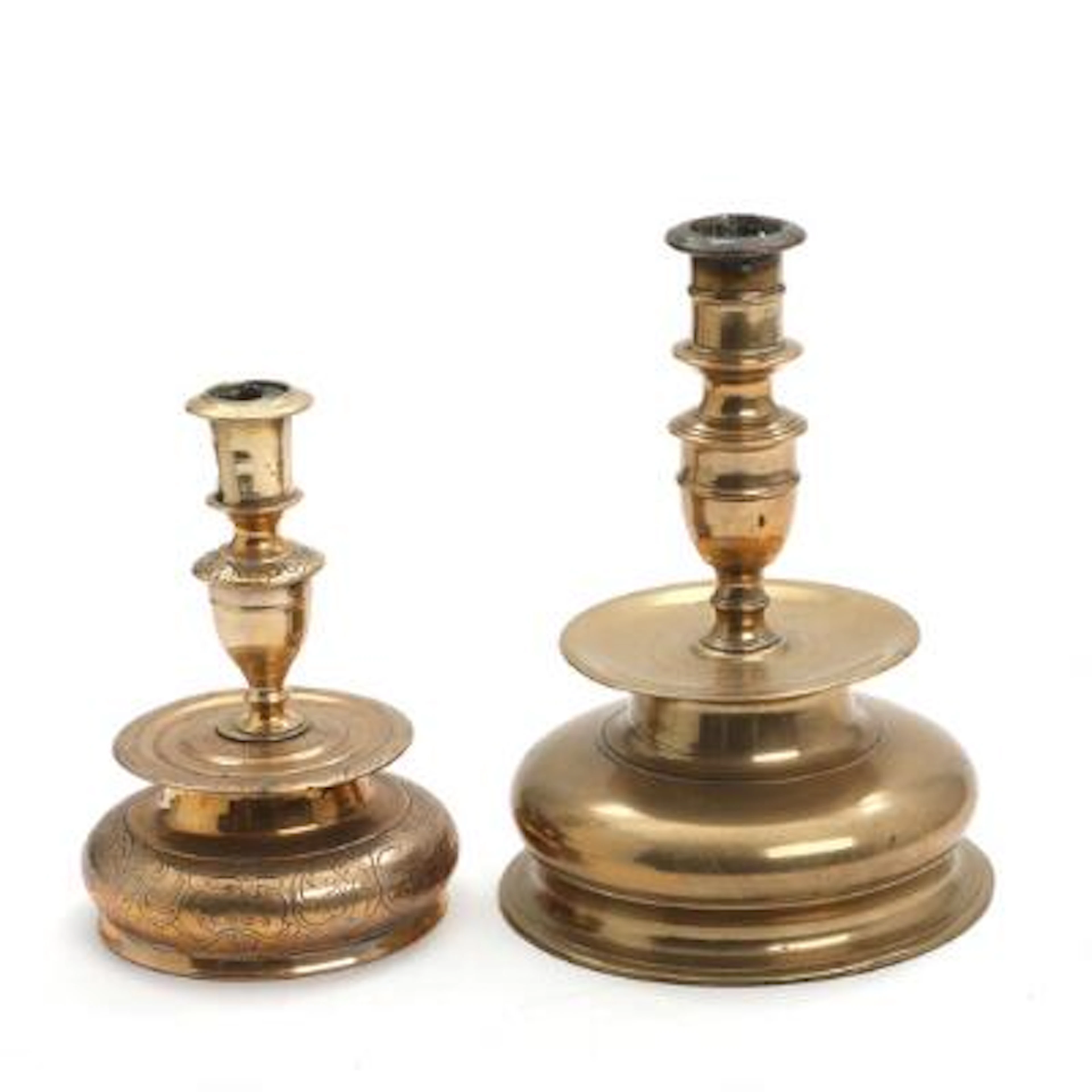 Two Baroque brass candlestick, the smaller one engraved with floral