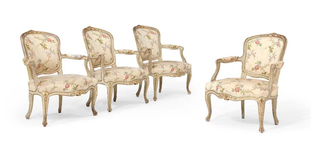 A set of four French Rococo armchairs of gilded and painted wood.
