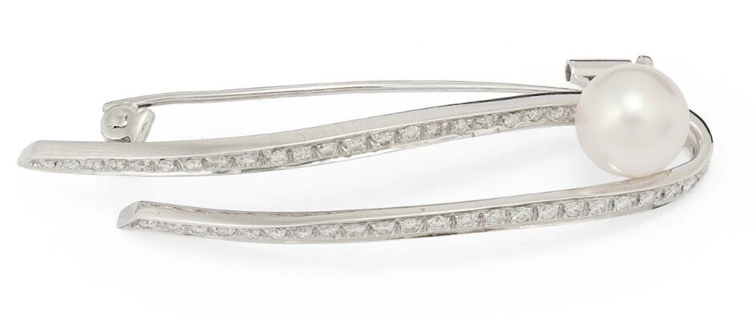 A pearl and diamond brooch set with a cultured freshwater pearl and