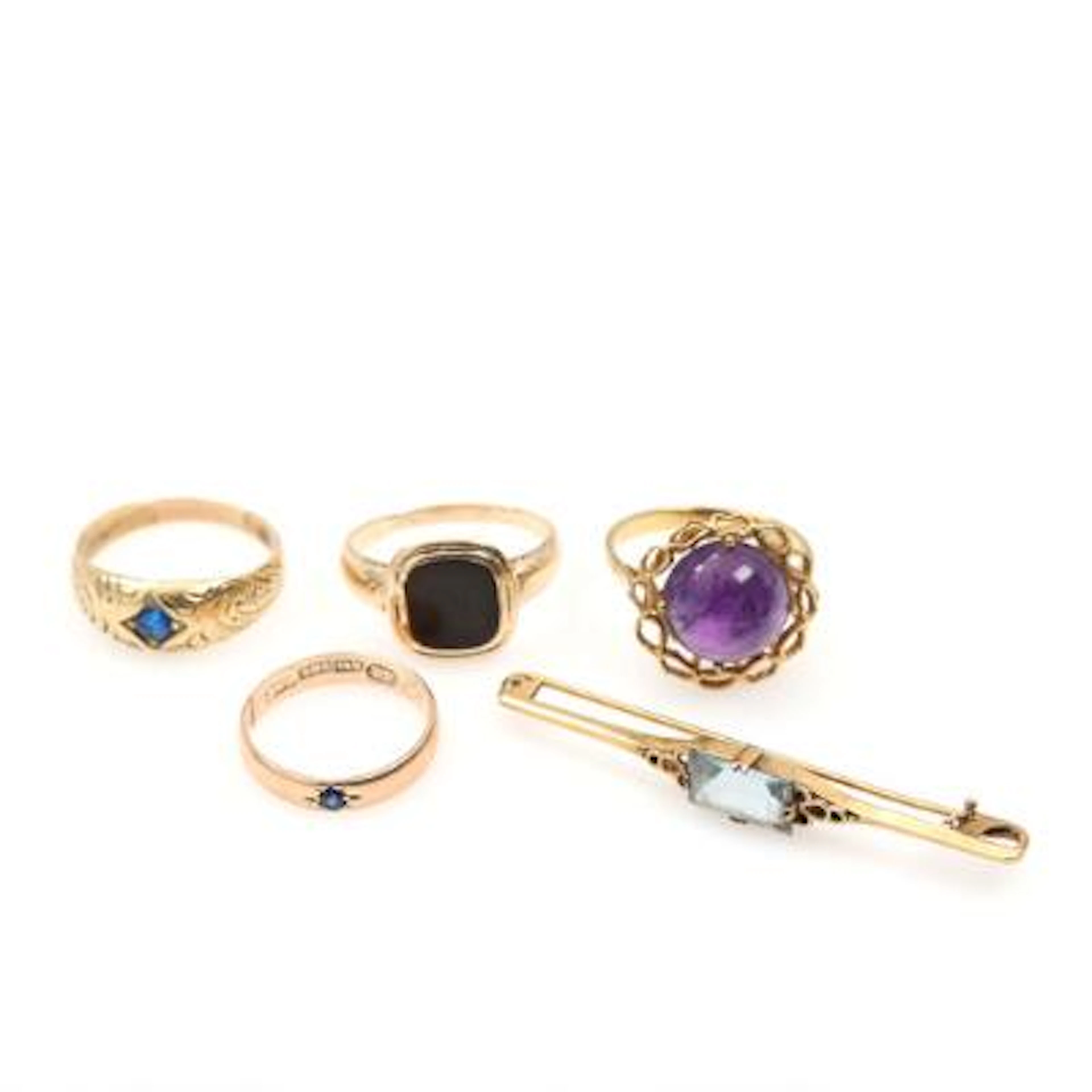 A selection of jewellery comprising four rings and a brooch of 14k
