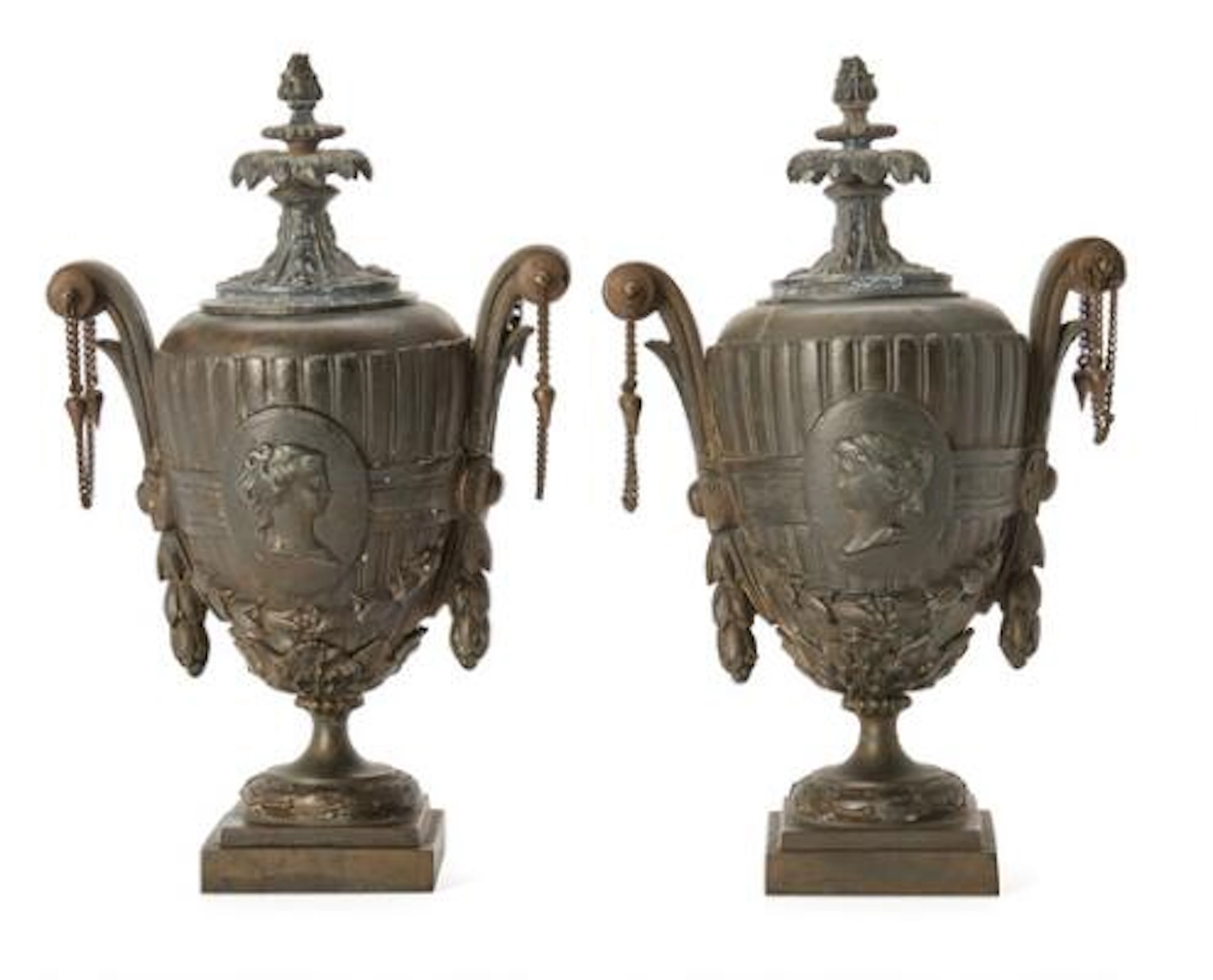 A pair of bronze casolets cast with a female head in profile. Presumably