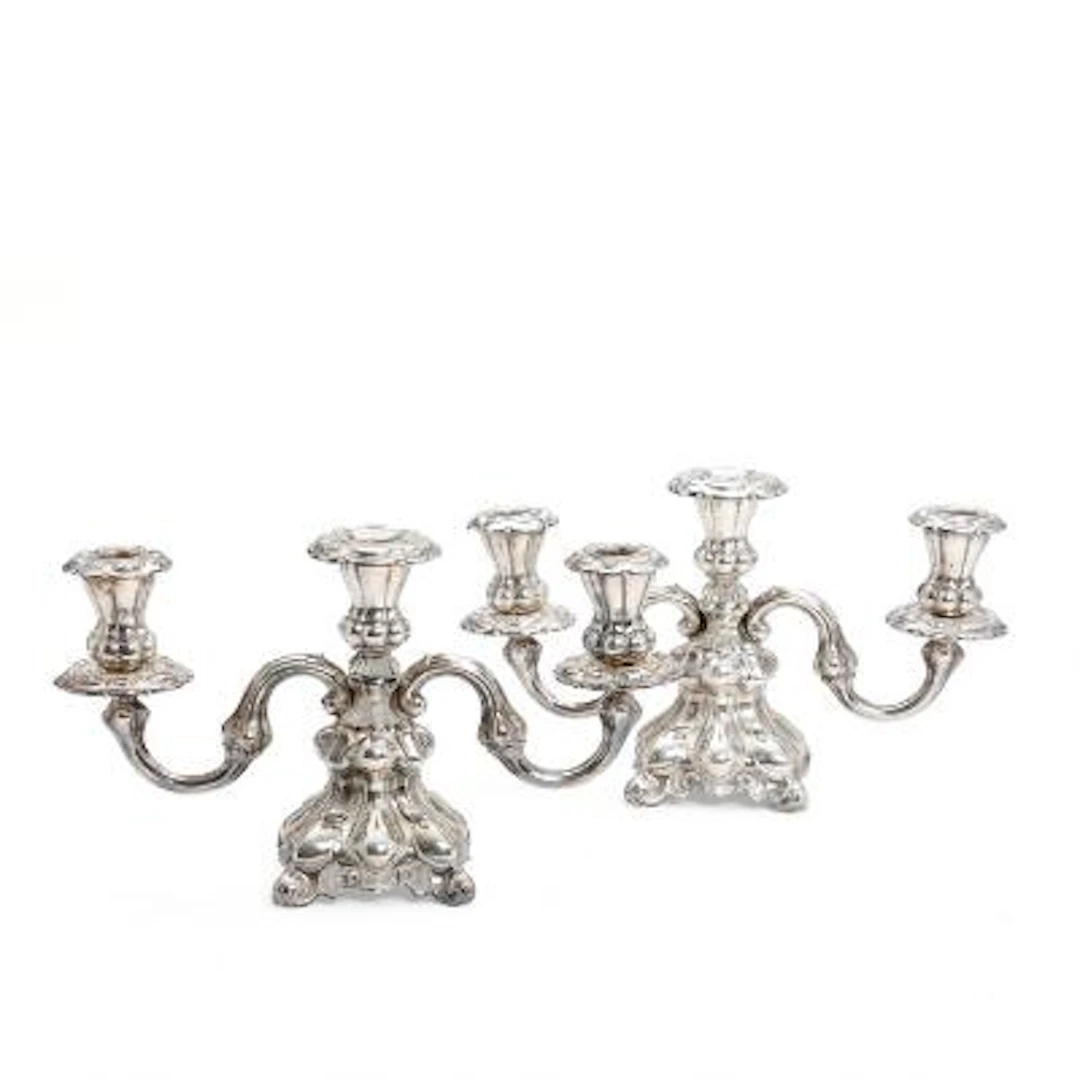 A pair of three-armed candlesticks in silver and silver plate respectively.
