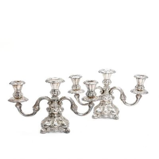 A pair of three-armed candlesticks in silver and silver plate respectively.