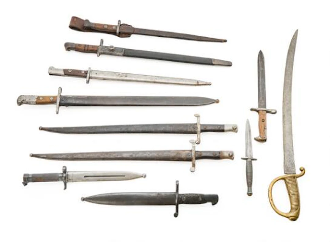 A collection of 11 assorted bayonets, knives, and edged weapons. –