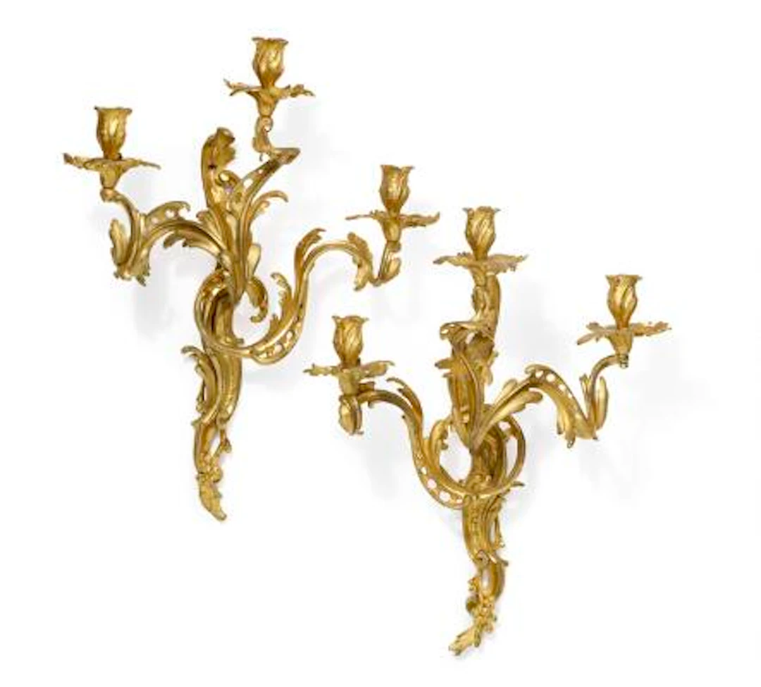 A pair of Louis XV gilt bronze three branch wall lights, with the