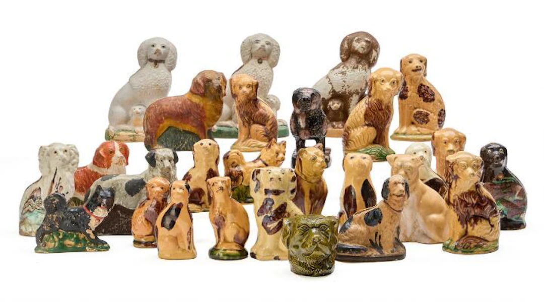 A collection of money boxes in the form of dogs. Primarily glazed