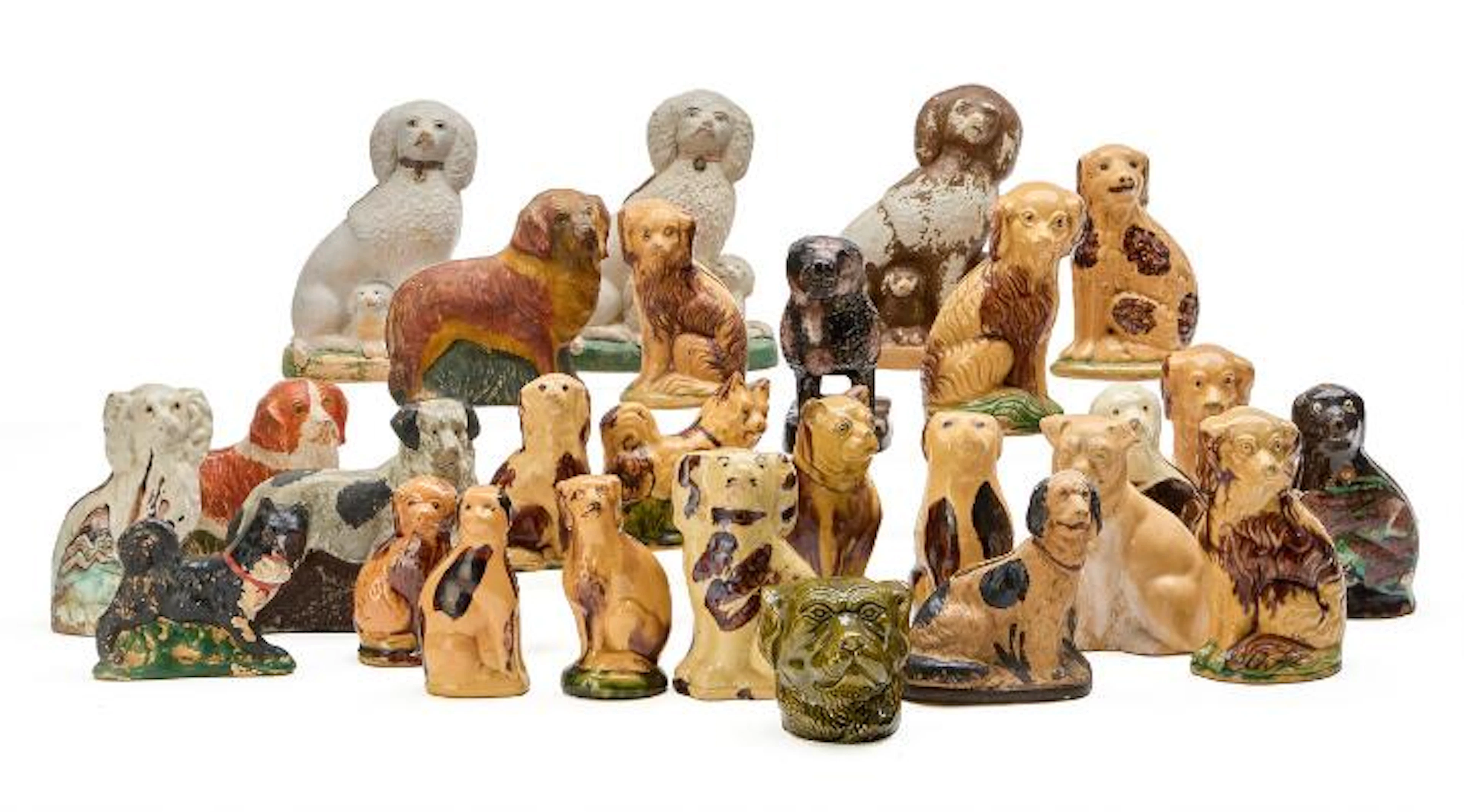 A collection of money boxes in the form of dogs. Primarily glazed