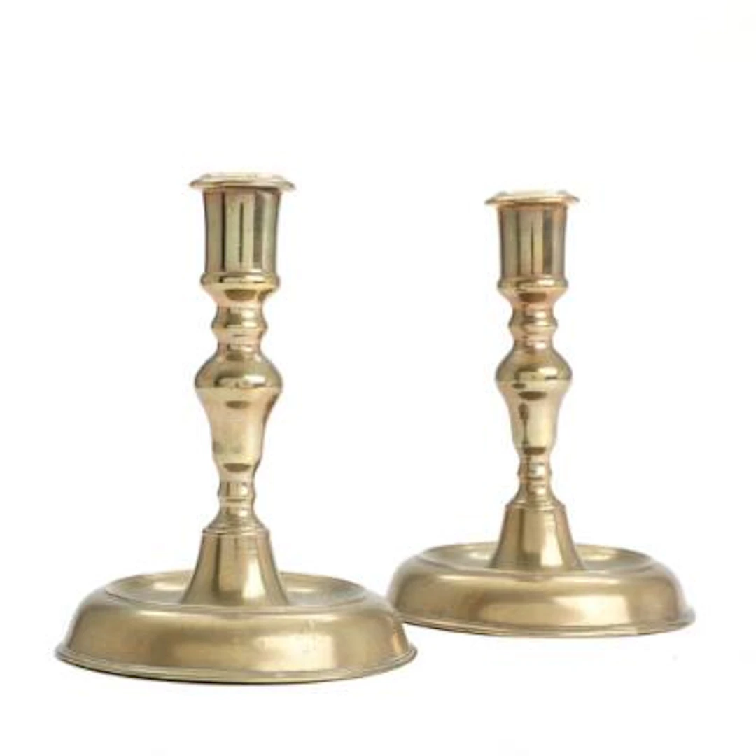 A pair of brass Næstved candlesticks, baluster-shaped stems on round