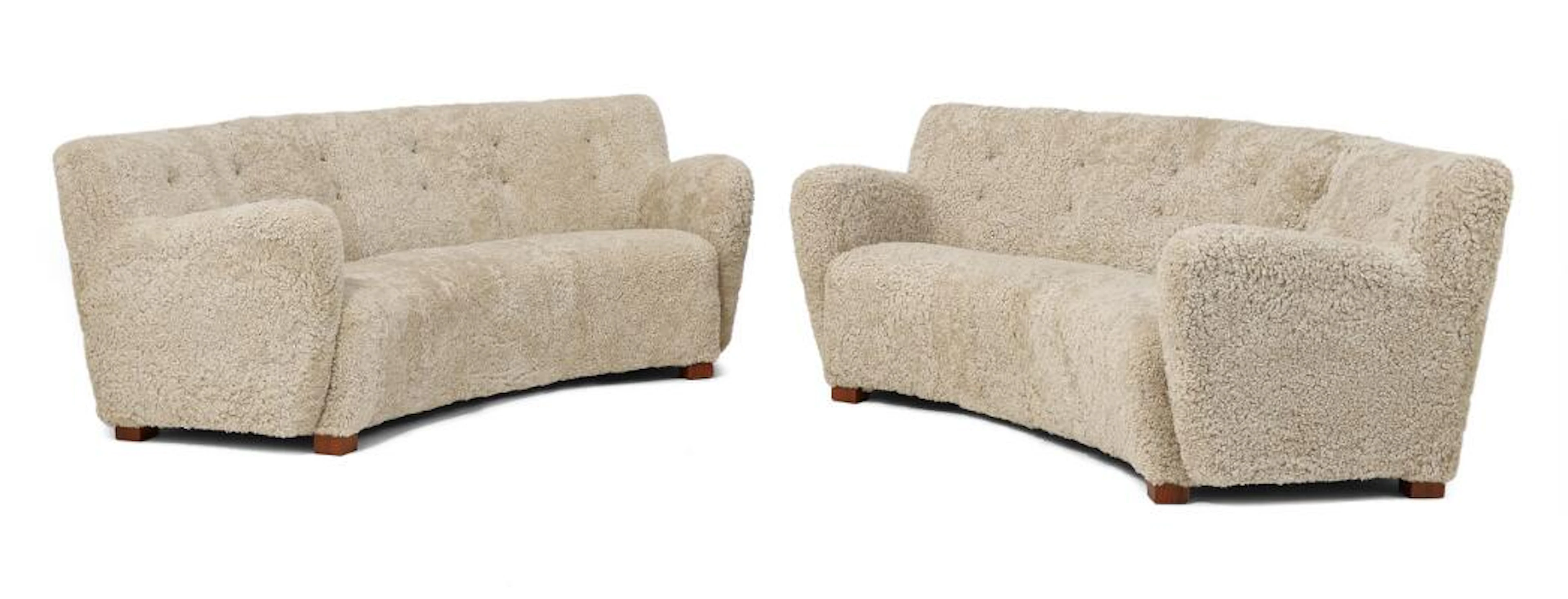 Danish cabinetmaker: A pair of curved sofas with nutwood legs. Upholstered