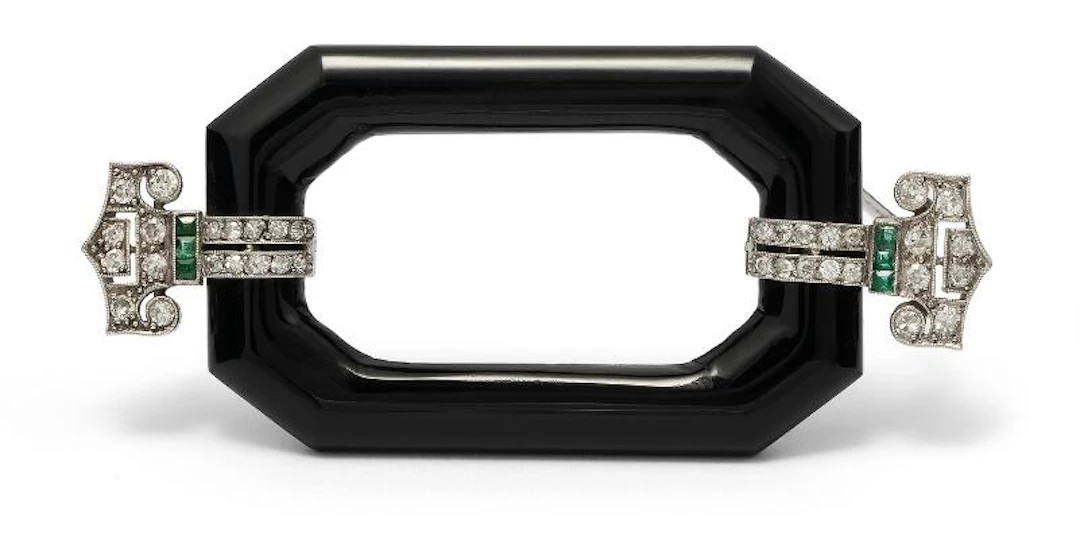 An Art Deco onyx, emerald and diamond brooch of platinum. L. 6.3 cm.
