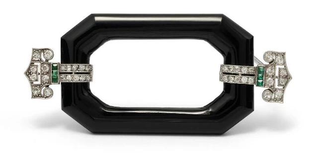 An Art Deco onyx, emerald and diamond brooch of platinum. L. 6.3 cm.